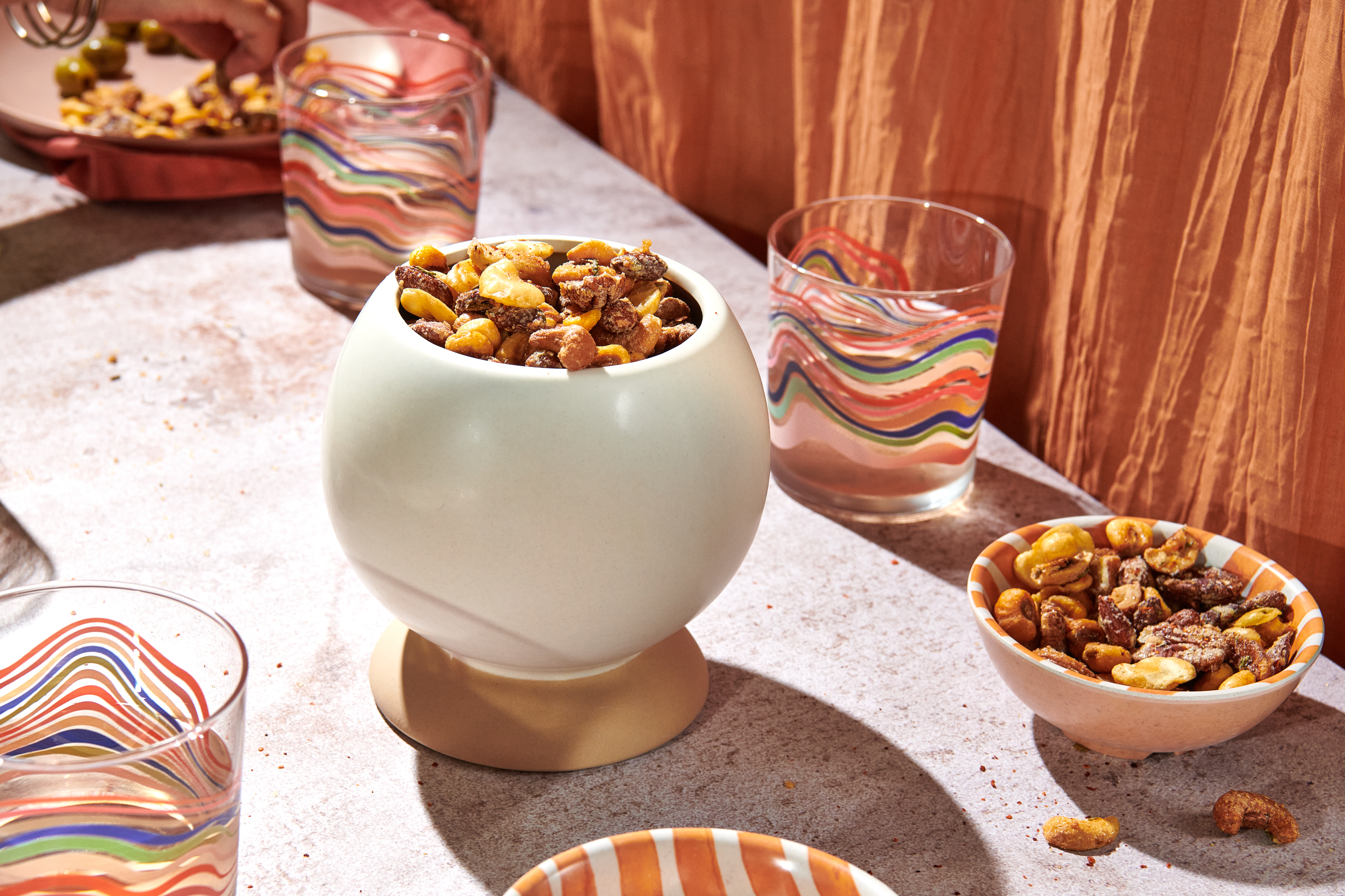 Bowls of Crunch Party snack mix, surrounded by colorful drinking glasses.