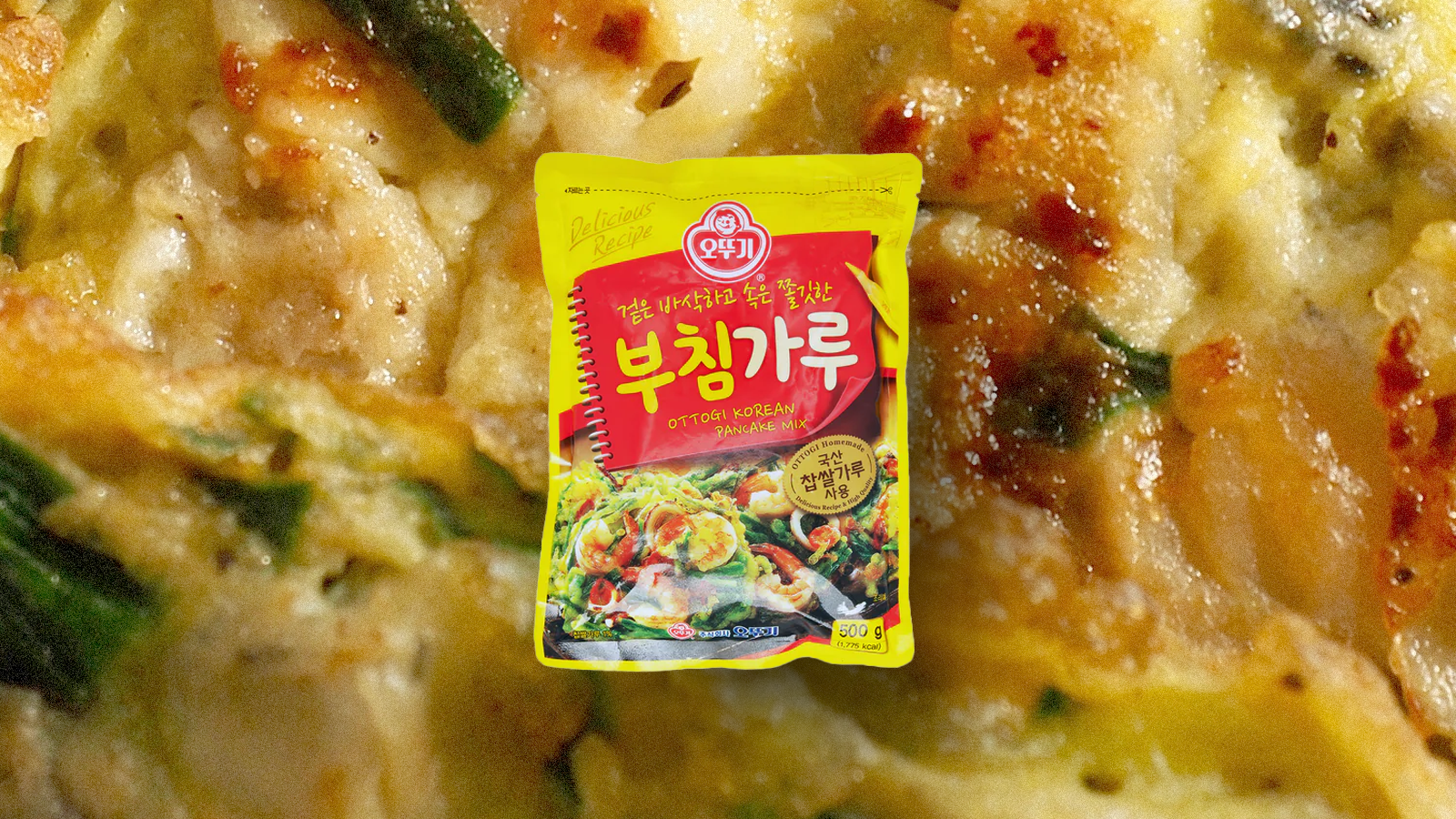A close-up shot of a Korean pancake with a bag of Korean pancake mix layered on top